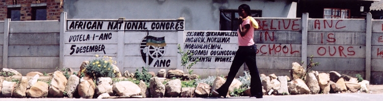 Foto: Eine junge Frau vor ANC-Graffitis in Mbekweni bei Paarl, Südafrika 2005, Matthäus Rest